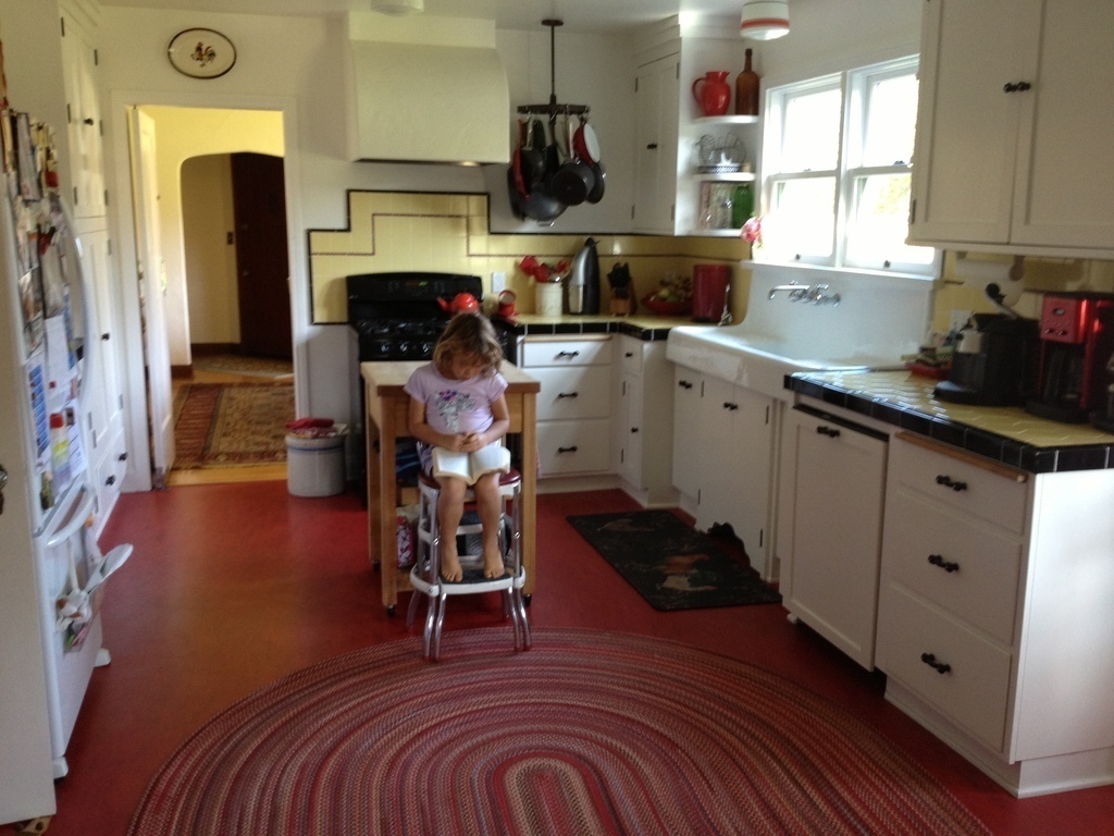 blurry view of kitchen -(daughter reading!) doorway to dining room and front door