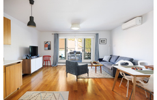 The living room is sunny + opens to private deck