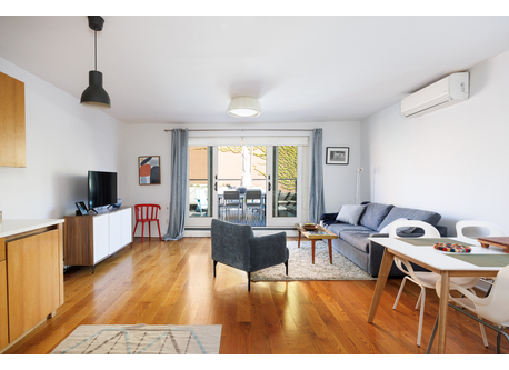 The living room is sunny + opens to private deck
