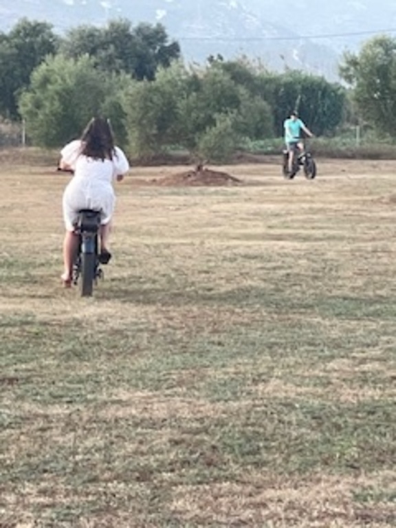 Grand children playing on electric bikes in our golf practice field