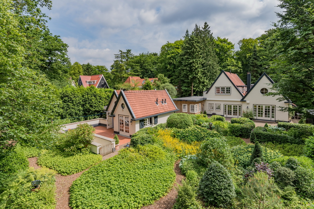 Dit is de tuin achter ons huis. Het grenst aan het bos. De tuin is geheel begrensd met een ijzeren hek. 