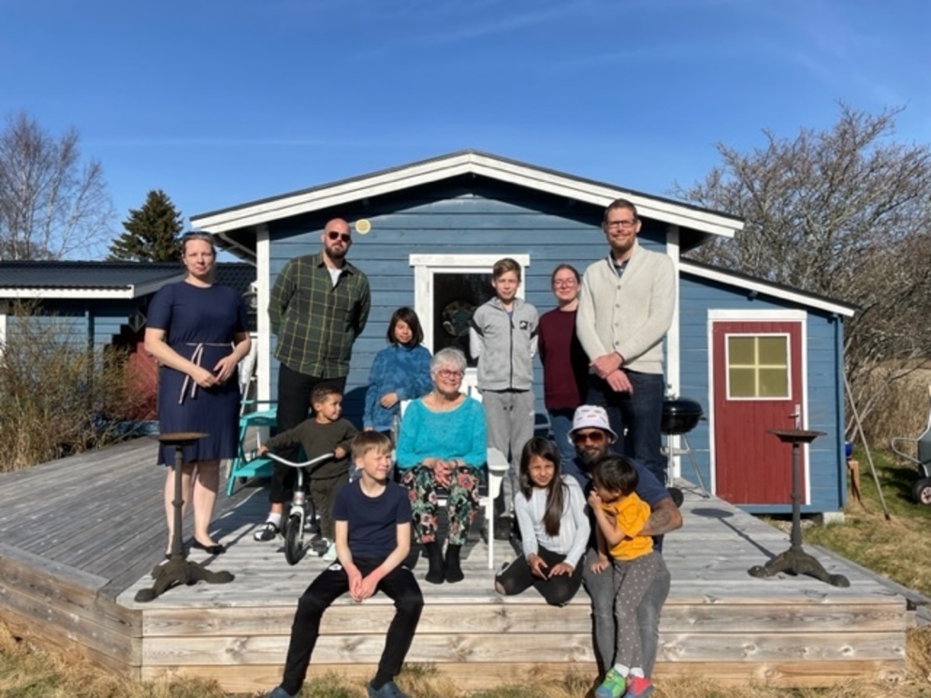 Me with sons, nephew, daughters in law and grandchildren by the house
